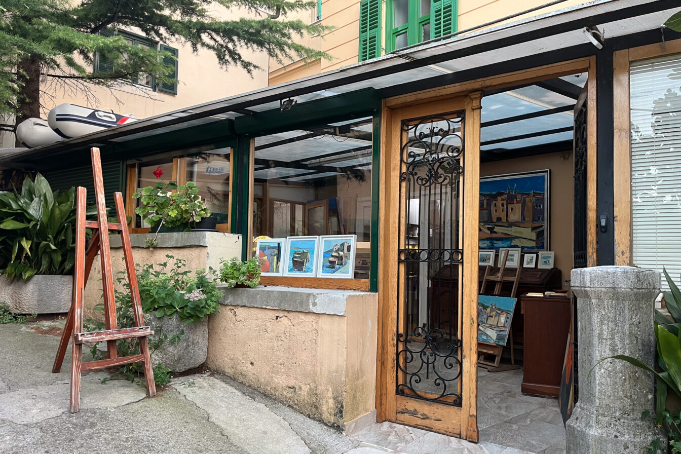 Eine Galeria mit Staffelei vor der Ausstellungsfläche.