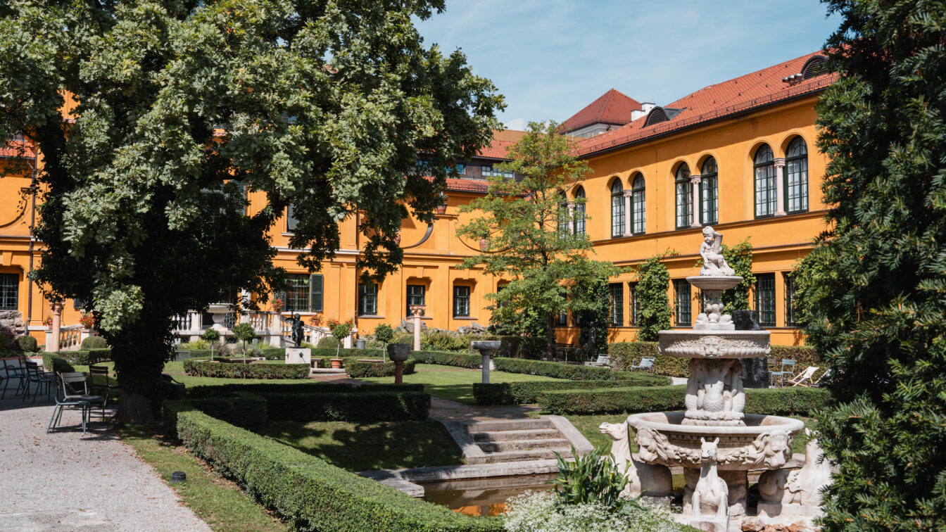 orangenes Renaissancehaus mit grünem Garten und Brunnen
