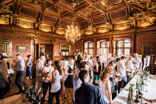 Menschen verkosten Weine in den Prunkräumen im Schloss Grafenegg