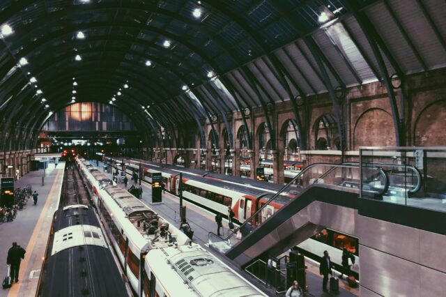 Menschen, die in einem Bahnhof gehen und stehende Züge