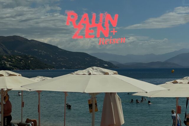 Weiße Schirme am Meer einer Bucht auf Korfu