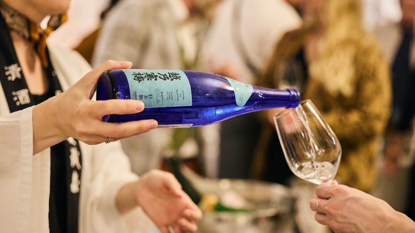 Sake wird aus einer Flasche in ein Glas ausgeschenkt