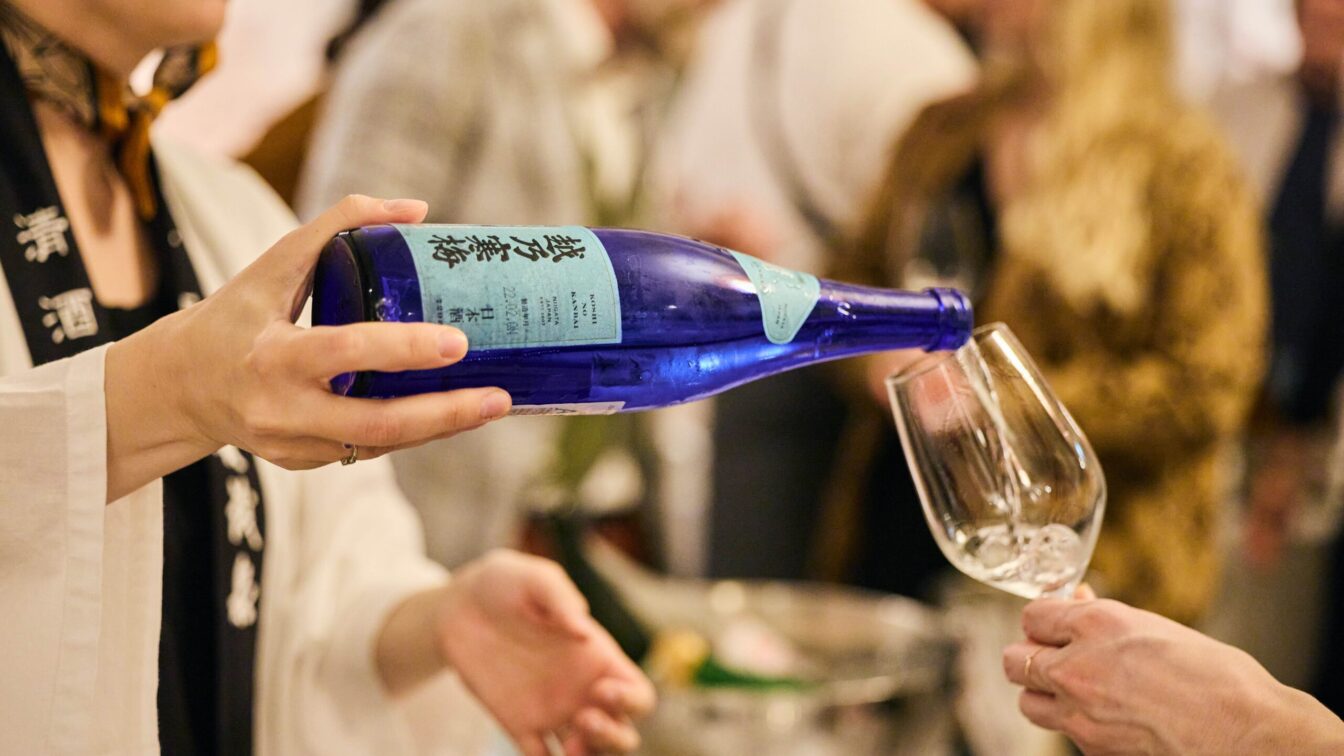 Sake wird aus einer Flasche in ein Glas ausgeschenkt