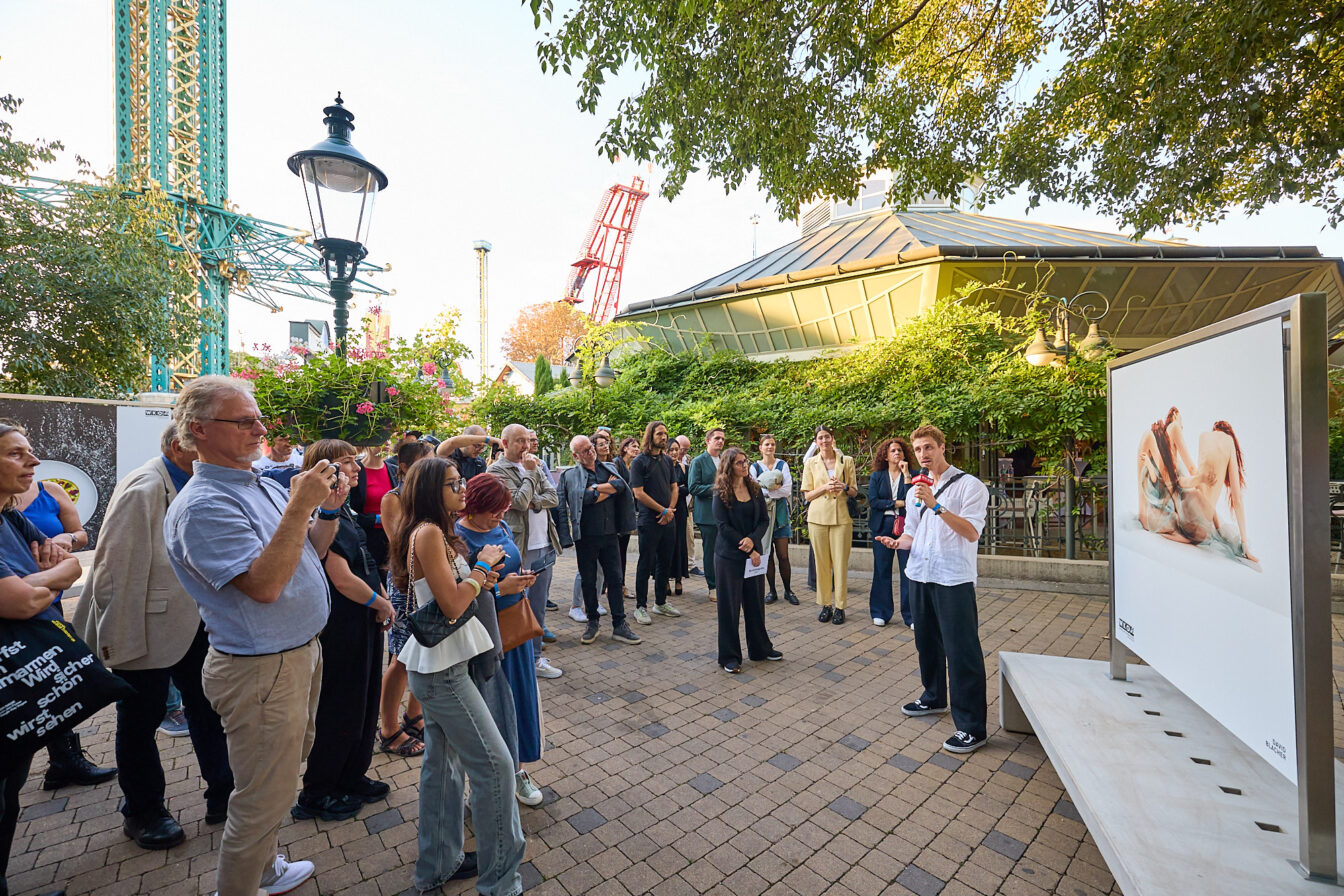 Eine Menschengruppe vor einer Fototafel im Prater