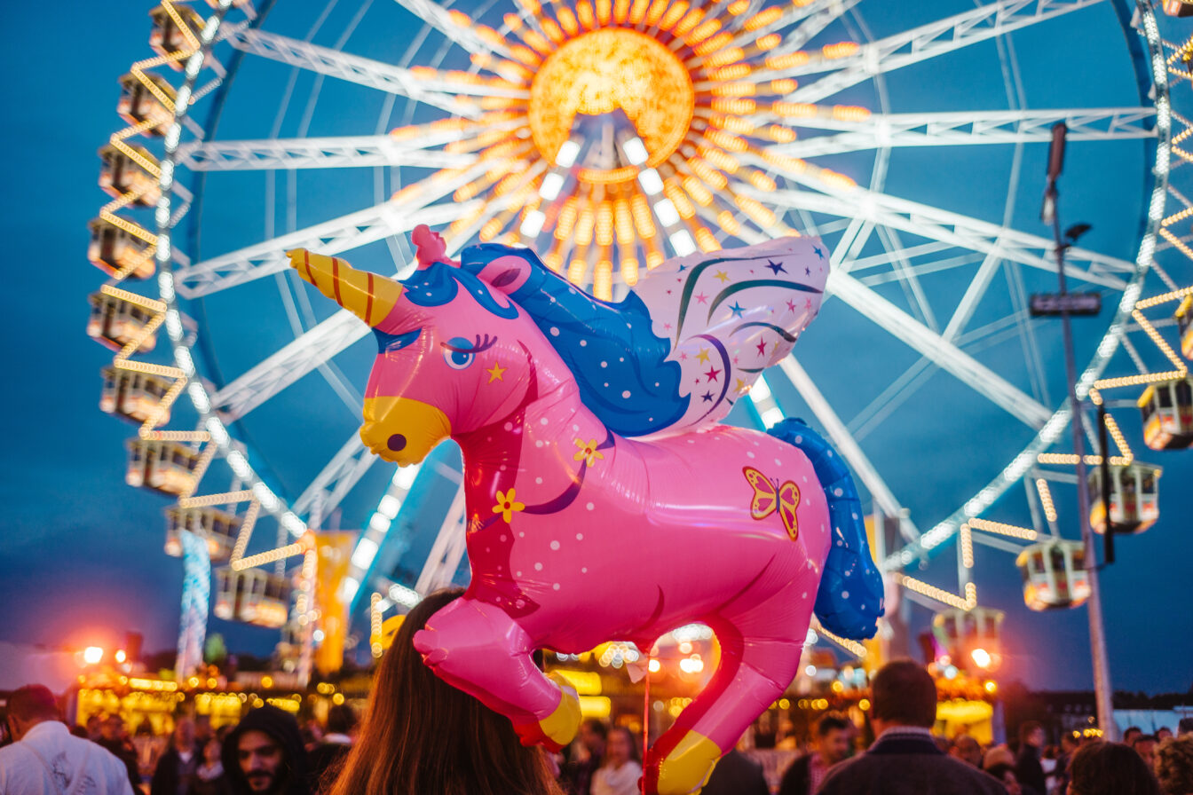 Ein Luftballon in der Form eines Einhorns vor einem Riesenrad