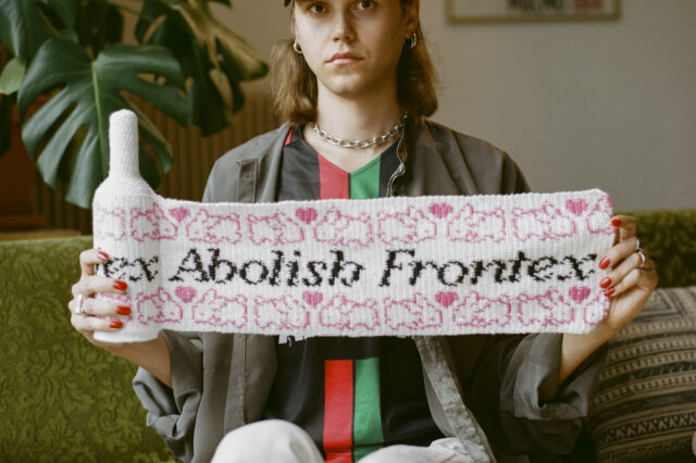 Eine Person auf einem Sofa, die eine Flasche mit Strickgewand trägt