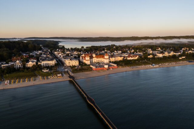 Blick auf eine Küste mit Häusern bei Sonnenaufgang