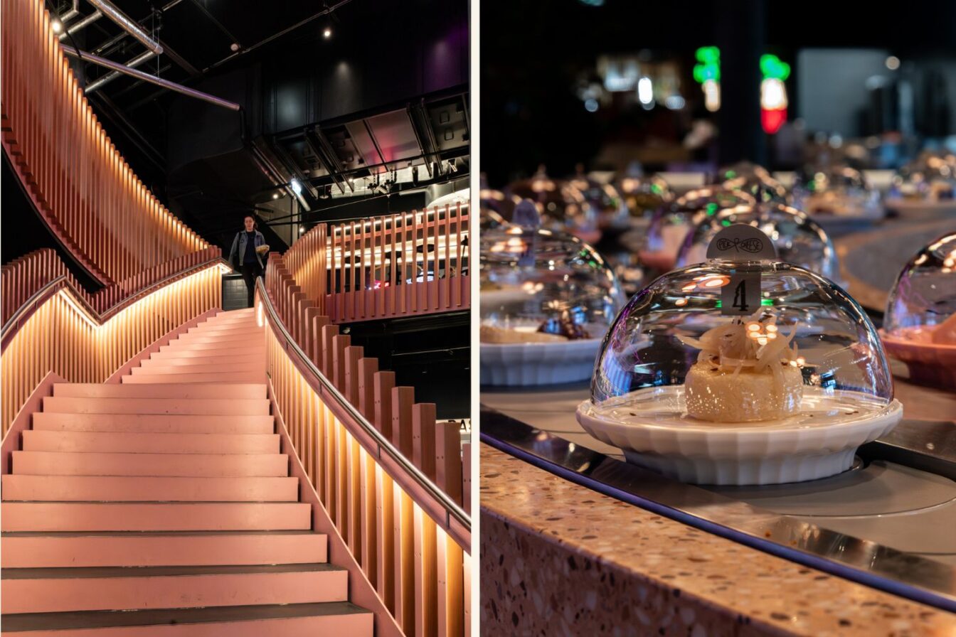 Innenaufnahme von Running Käse in Berlin: Links eine breite, rosa Treppe mit modernen Holzpaneelen und warmem Lichtdesign, auf der ein Gast hinuntergeht. Rechts ein Förderband mit kleinen Tellern, die Käsevariationen unter gläsernen Hauben präsentieren, darunter ein Käseteller mit der Nummer 4 im Vordergrund.