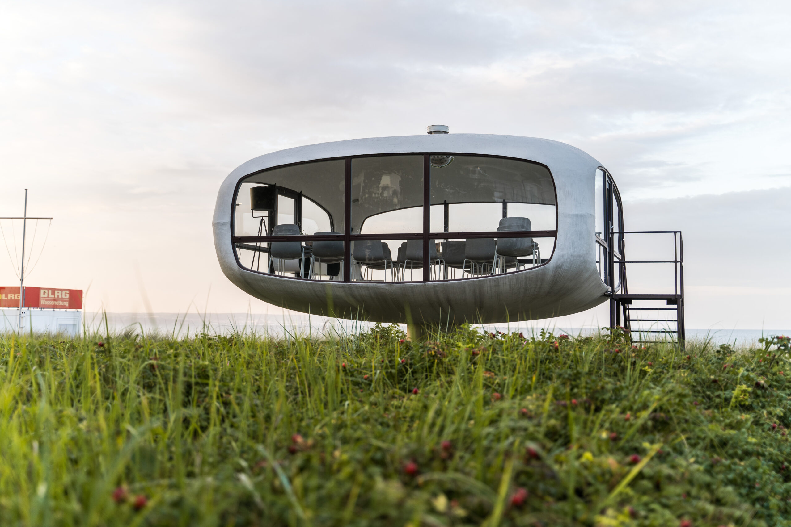 Ausblick auf ein ufoähnliches Gebäude am Strand.