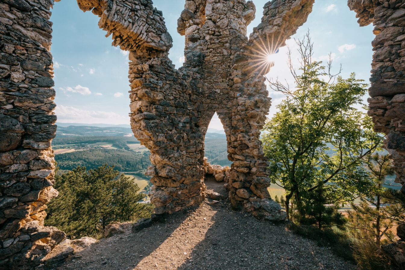 Eine Ruine durch die Licht scheint mit Blick auf die Bucklige Welt 