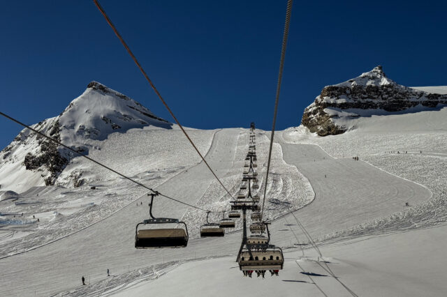 Sessellift in Zermatt mit bestens präparierten Skipisten und strahlend blauem Himmel – perfektes Skifahren in der Schweiz.
