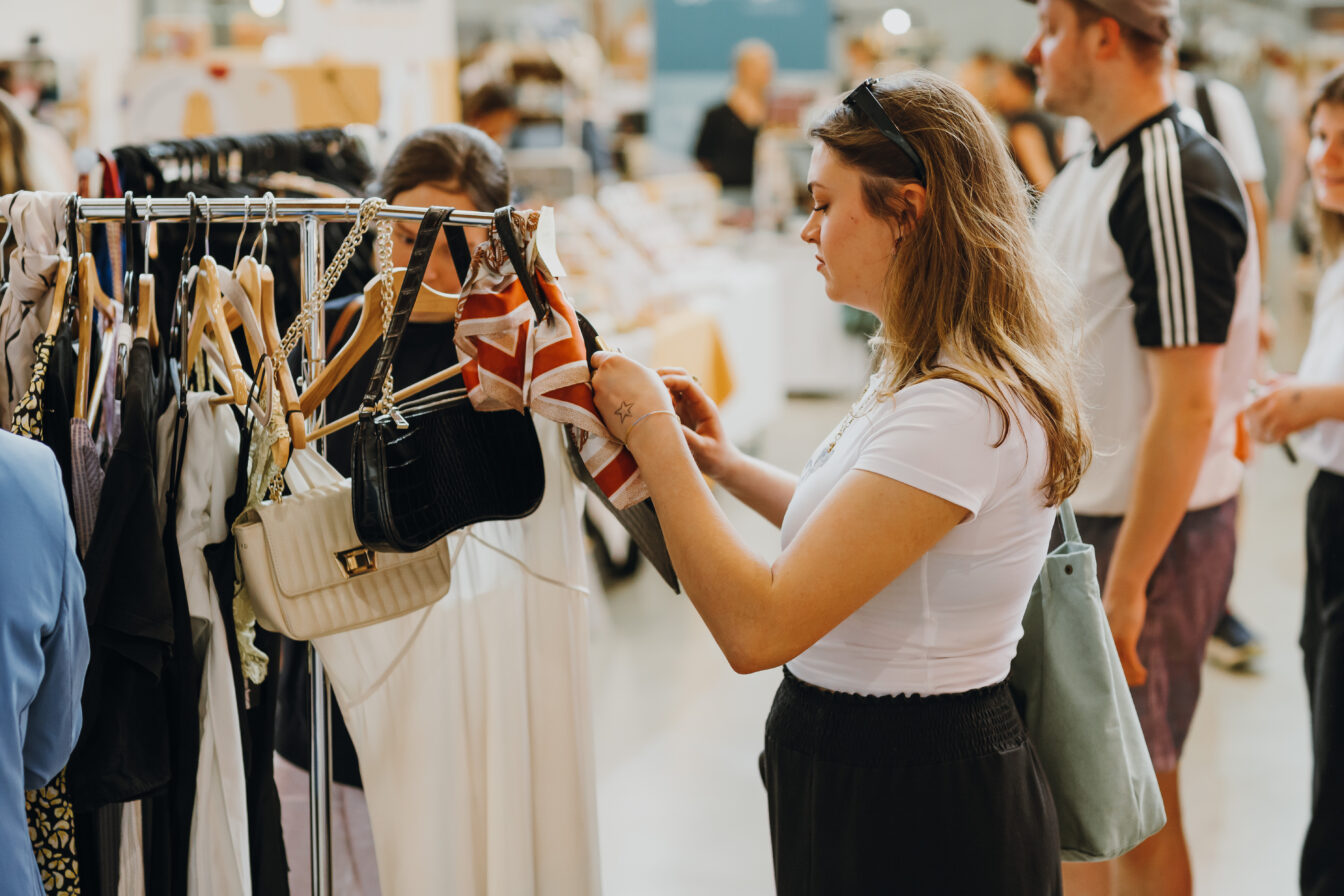 Der Edelstoff-Herbstmarkt in der Marx Halle in Wien im 3. Bezirk: Person schaut sich Stücke an