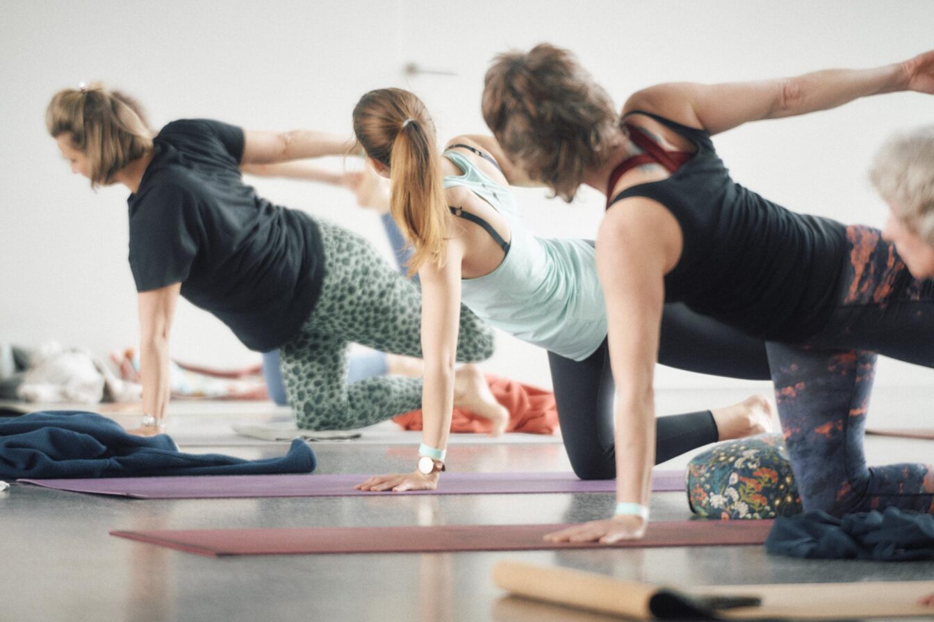 Drei Personen, die Yoga machen.