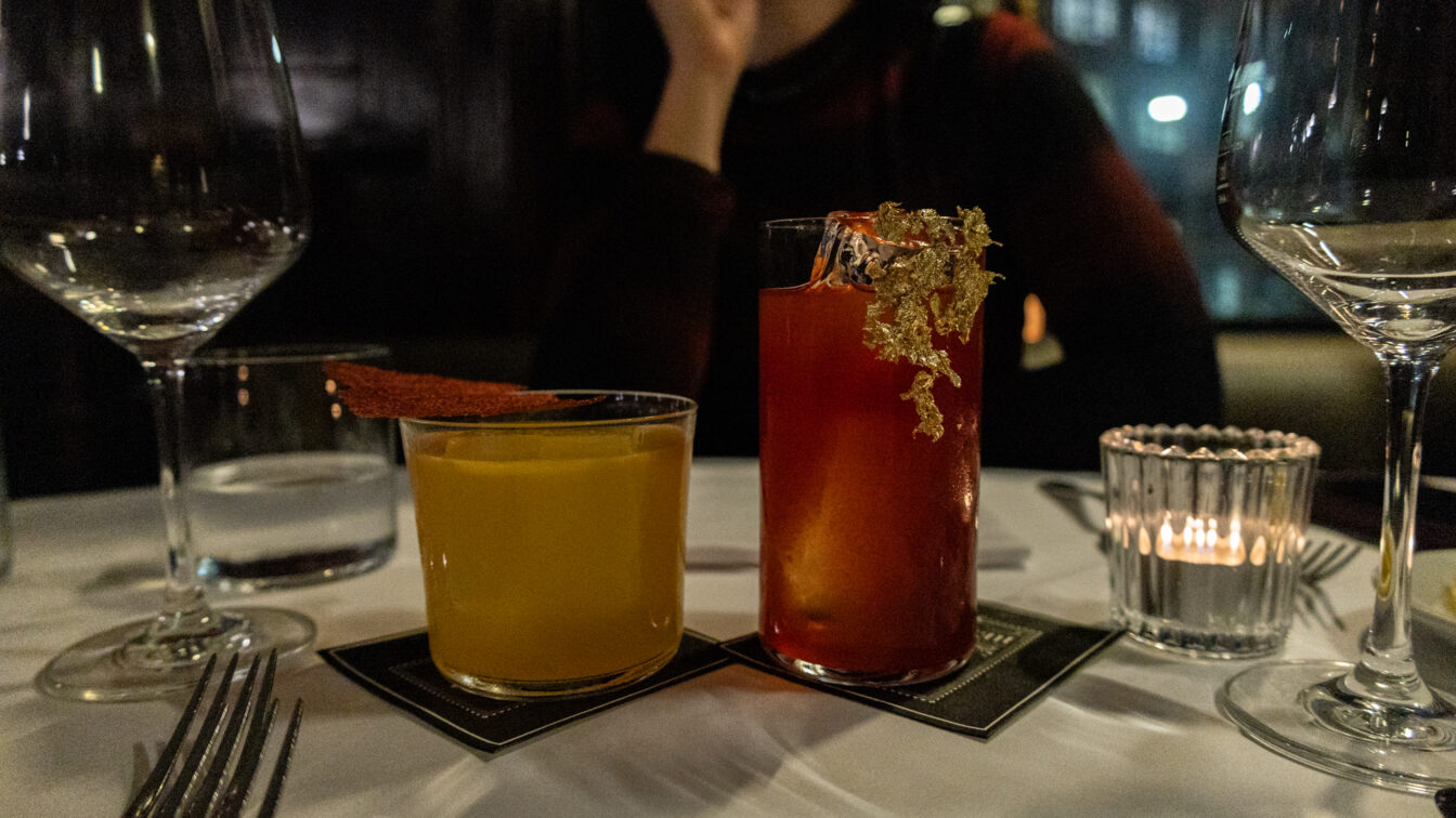 Zwei kunstvoll dekorierte Cocktails auf elegant gedecktem Tisch in einem der Restaurants Zürich außergewöhnlich – stilvolles Fine-Dining-Ambiente mit gedimmtem Licht und moderner Barkultur.