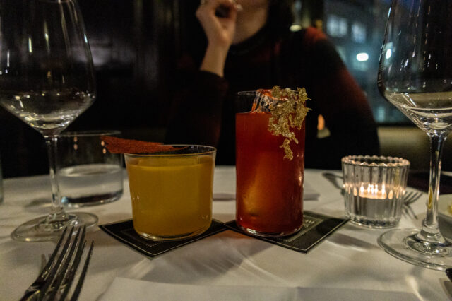 Zwei kunstvoll dekorierte Cocktails auf elegant gedecktem Tisch in einem der Restaurants Zürich außergewöhnlich – stilvolles Fine-Dining-Ambiente mit gedimmtem Licht und moderner Barkultur.