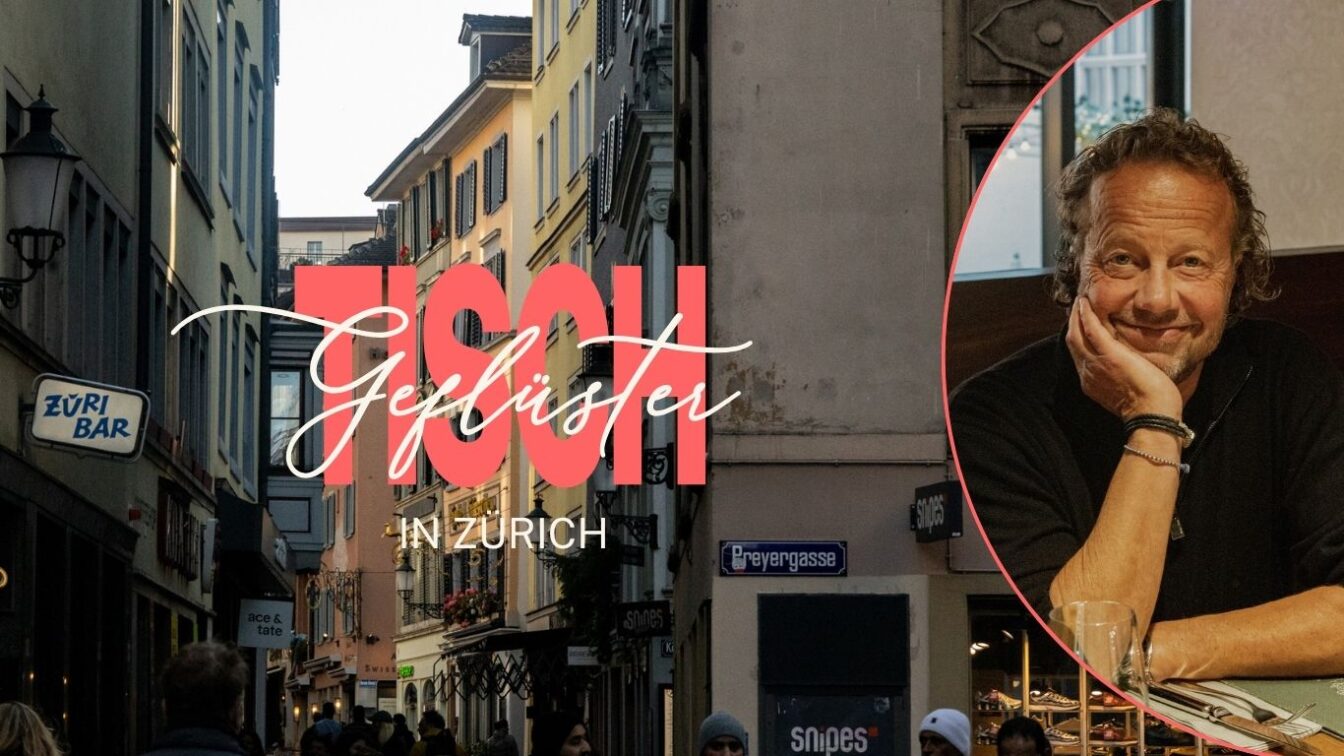 Eine enge Zürcher Altstadtgasse mit mehrstöckigen Häusern, Schildern von Bars und Geschäften sowie vorbeigehenden Menschen. In der Mitte steht der Schriftzug „Tisch Geflüster in Zürich“. Rechts im Bild befindet sich ein rund eingefügtes Foto von Rolf Hiltl, der mit der Hand den Kopf stützt und an einem Restauranttisch sitzt.