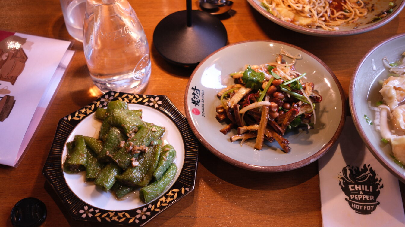 gedeckter Tisch mit Speisen im Restaurant Sichuan Ravioli in Wien