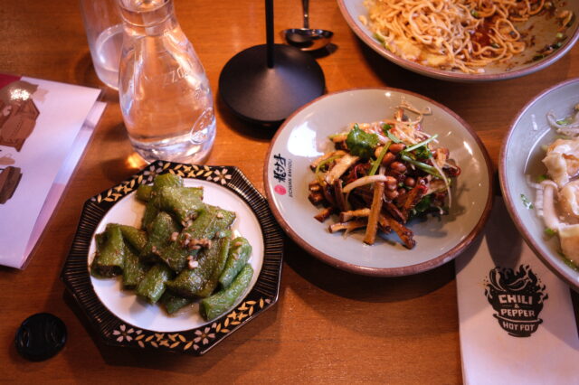 gedeckter Tisch mit Speisen im Restaurant Sichuan Ravioli in Wien