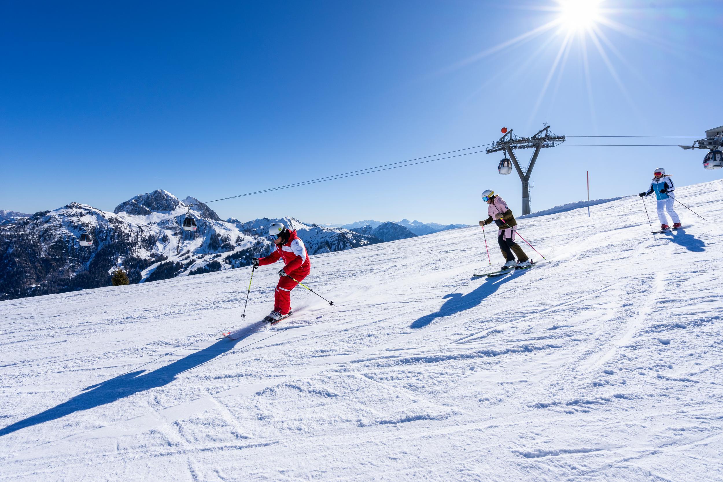 Skifahrende auf der Piste bei Sonnenschein