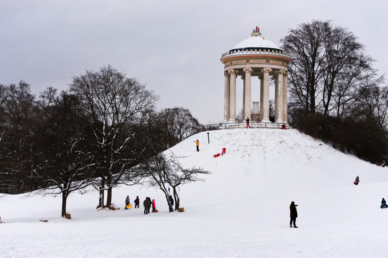 Winter am Monopterus im Englischen Garten mit schlittenfahrenden Menschen