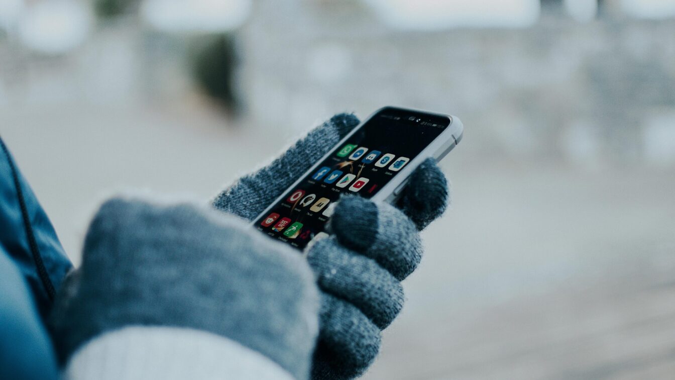 Caritas Kältetelefon in Österreich: Person am Handy im Winter