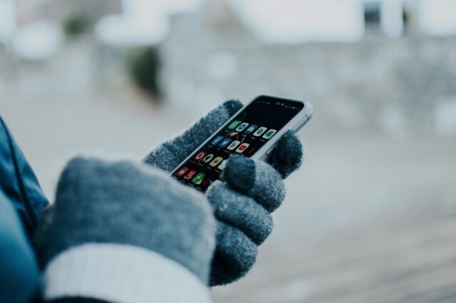 Caritas Kältetelefon in Österreich: Person am Handy im Winter
