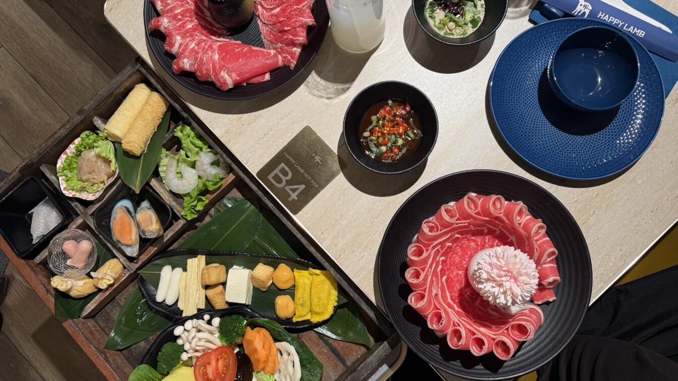 mehrere Zutaten für Hot Pot stehen auf einem Tisch im Restaurant Happy Lamb in Wien