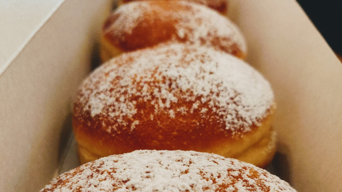 mehrere Krapfen liegen in einer Karton-Verpackung