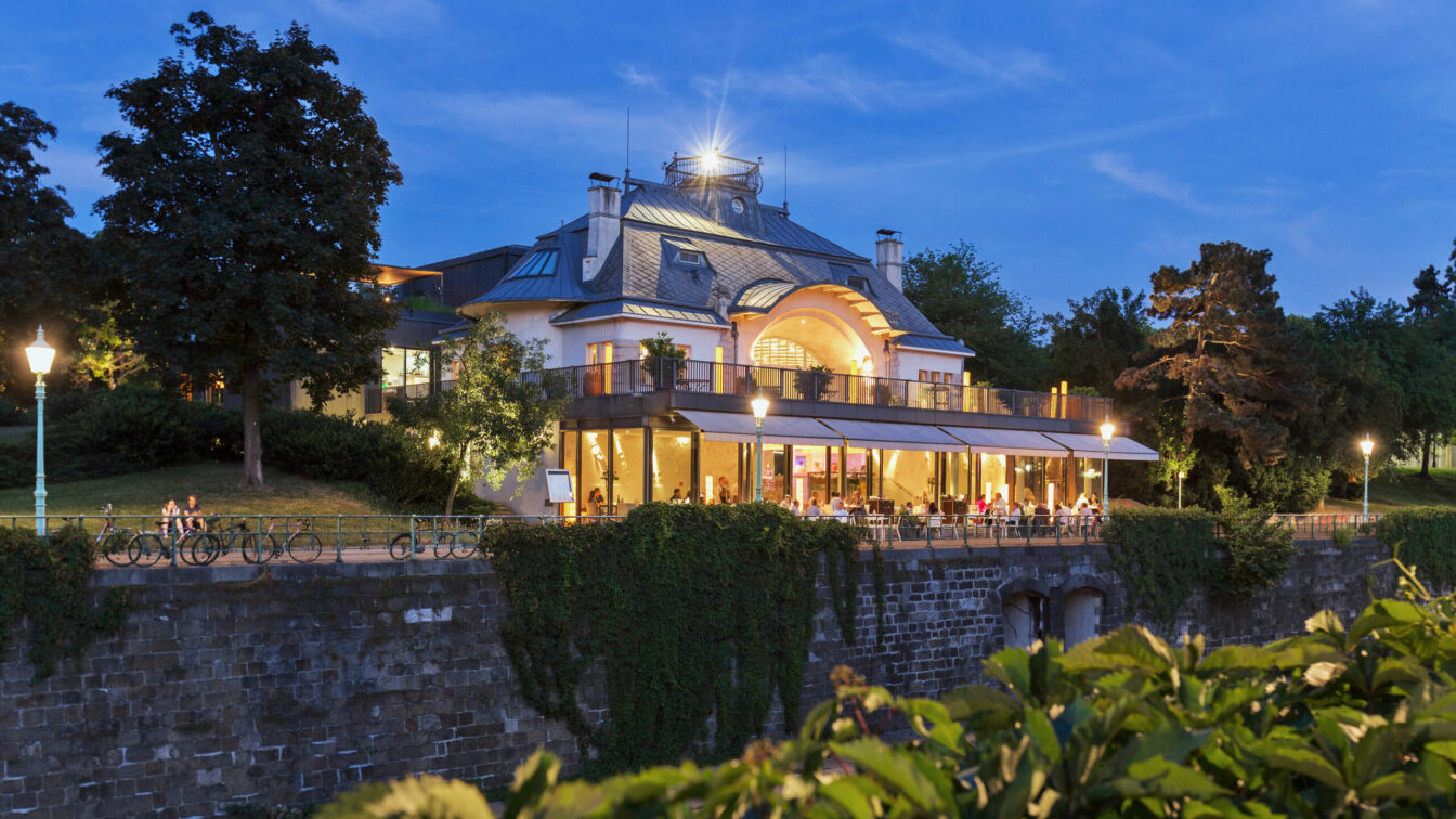 Blick auf das beleuchtete Restaurant Meierei im Stadtpark in Wien bei Abenddämmerung