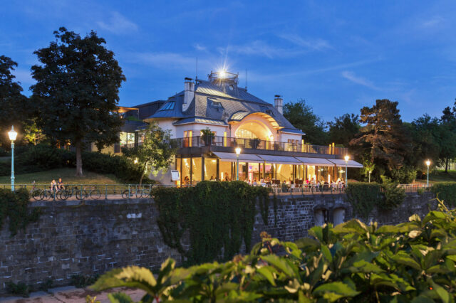 Blick auf das beleuchtete Restaurant Meierei im Stadtpark in Wien bei Abenddämmerung