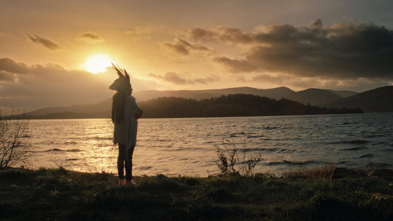 Juma Xipaia, Protagonistin des Dokumentarfilms "Yanuni - Die Stimme des Amazonas" steht bei Sonnenuntergang am Fluss Amazonas