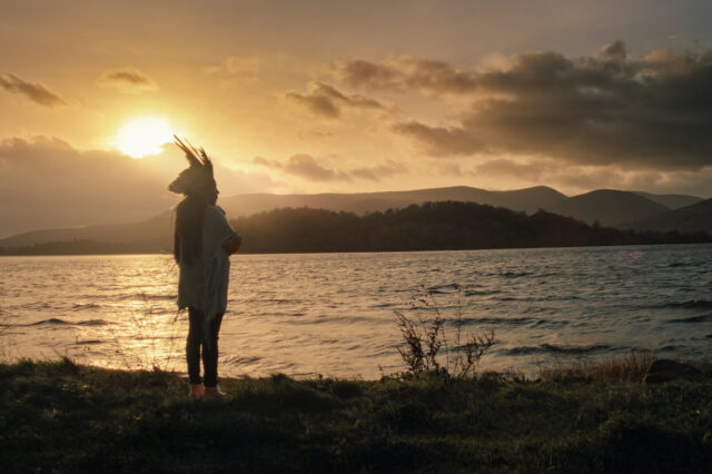 Juma Xipaia, Protagonistin des Dokumentarfilms "Yanuni - Die Stimme des Amazonas" steht bei Sonnenuntergang am Fluss Amazonas