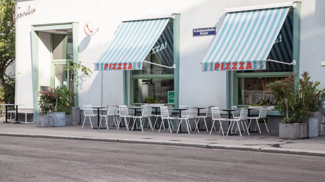 Tische und Sessel stehen im Schanigarten vor der Pizzeria Disco Volante in Wien