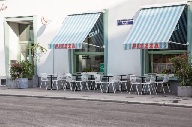 Tische und Sessel stehen im Schanigarten vor der Pizzeria Disco Volante in Wien