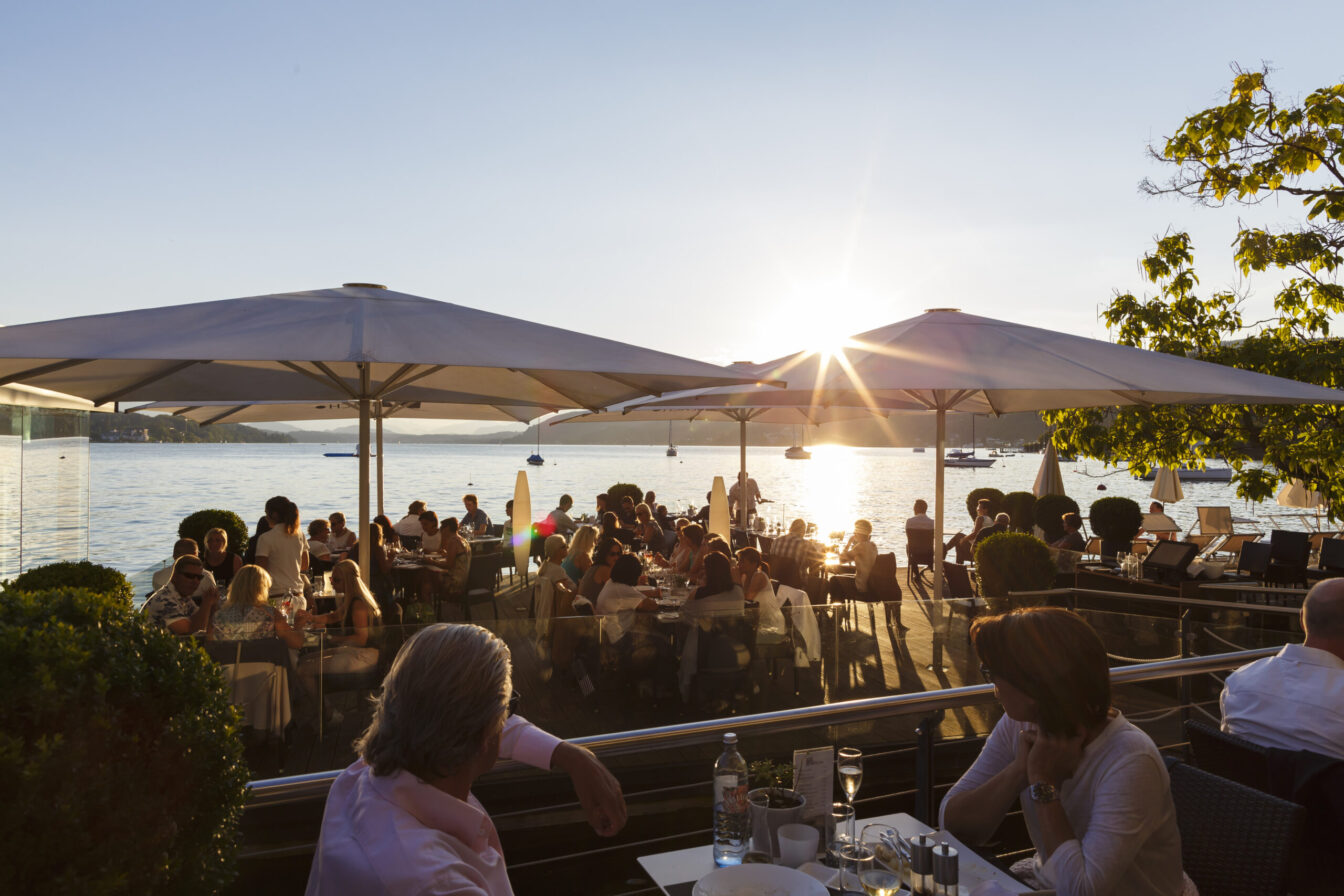 zahlreiche Menschen sitzen im Gastgarten des Restaurants Jilly Beach am Wörthersee