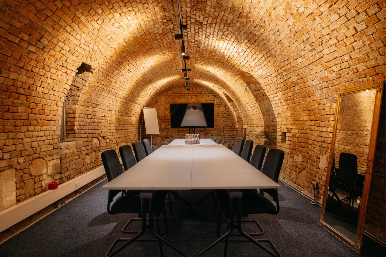 Tische und Stühle im historischen Kellergewölbe des Schottenstifts bei Team Escape in Wien