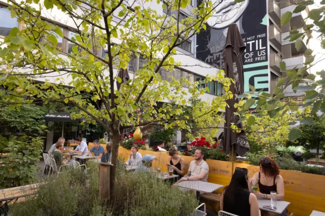Menschen sitzen im Gastgarten des Lokals WerkzeugH in Wien