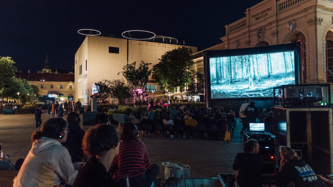 Menschen sitzen bei einer Open-Air-Kinovorstellung im MuseumsQuartier in Wien