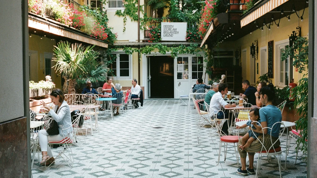 Menschen sitzen im Gastgarten im Innenhof des Restaurants vom Hotel am Brillantengrund im 7. Bezirk in Wien