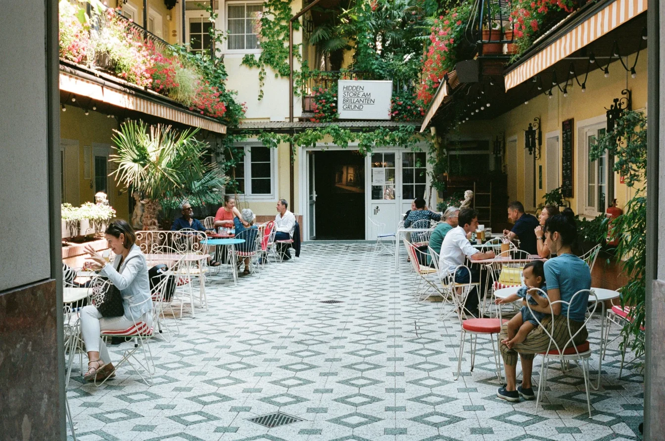 Menschen sitzen im Gastgarten im Innenhof des Restaurants vom Hotel am Brillantengrund im 7. Bezirk in Wien