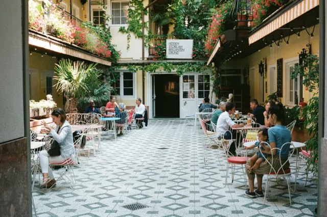 Menschen sitzen im Gastgarten im Innenhof des Restaurants vom Hotel am Brillantengrund im 7. Bezirk in Wien