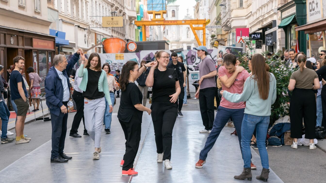 Menschen tanzen auf der Straße beim Grätzlfest Meet the Makers im Siebensternviertel im 7. Bezirk in Wien