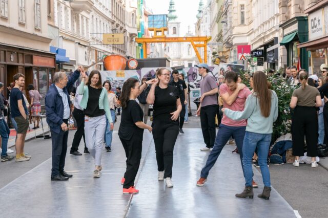 Menschen tanzen auf der Straße beim Grätzlfest Meet the Makers im Siebensternviertel im 7. Bezirk in Wien
