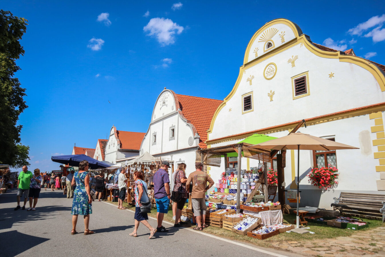 Marktstände stehen vor historischen Häusern beim Bauernfest in Holasovic in Tschechien