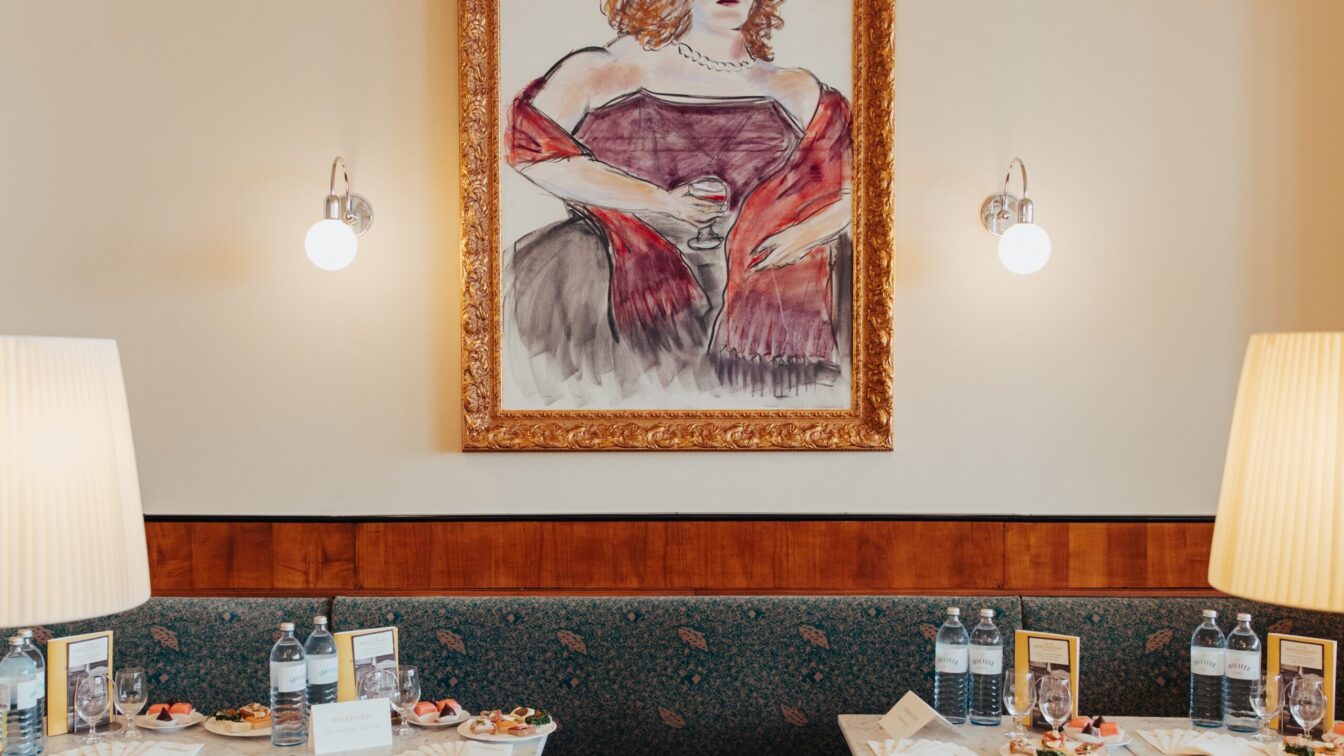 gedeckte Tische, eine Sitzbank und ein Gemälde an der Wand im Café Bräunerhof in Wien