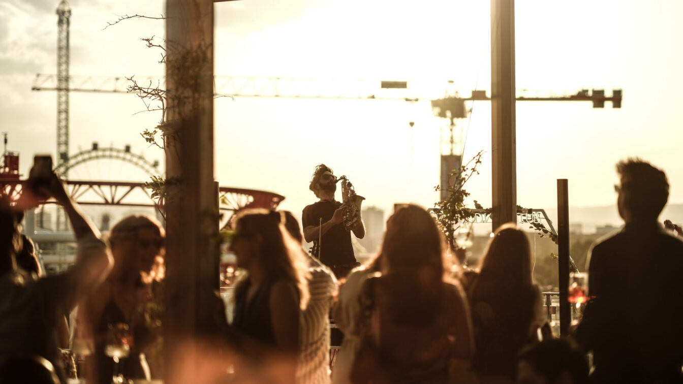Menschen feiern auf der Dachterrasse des Zoku Vienna