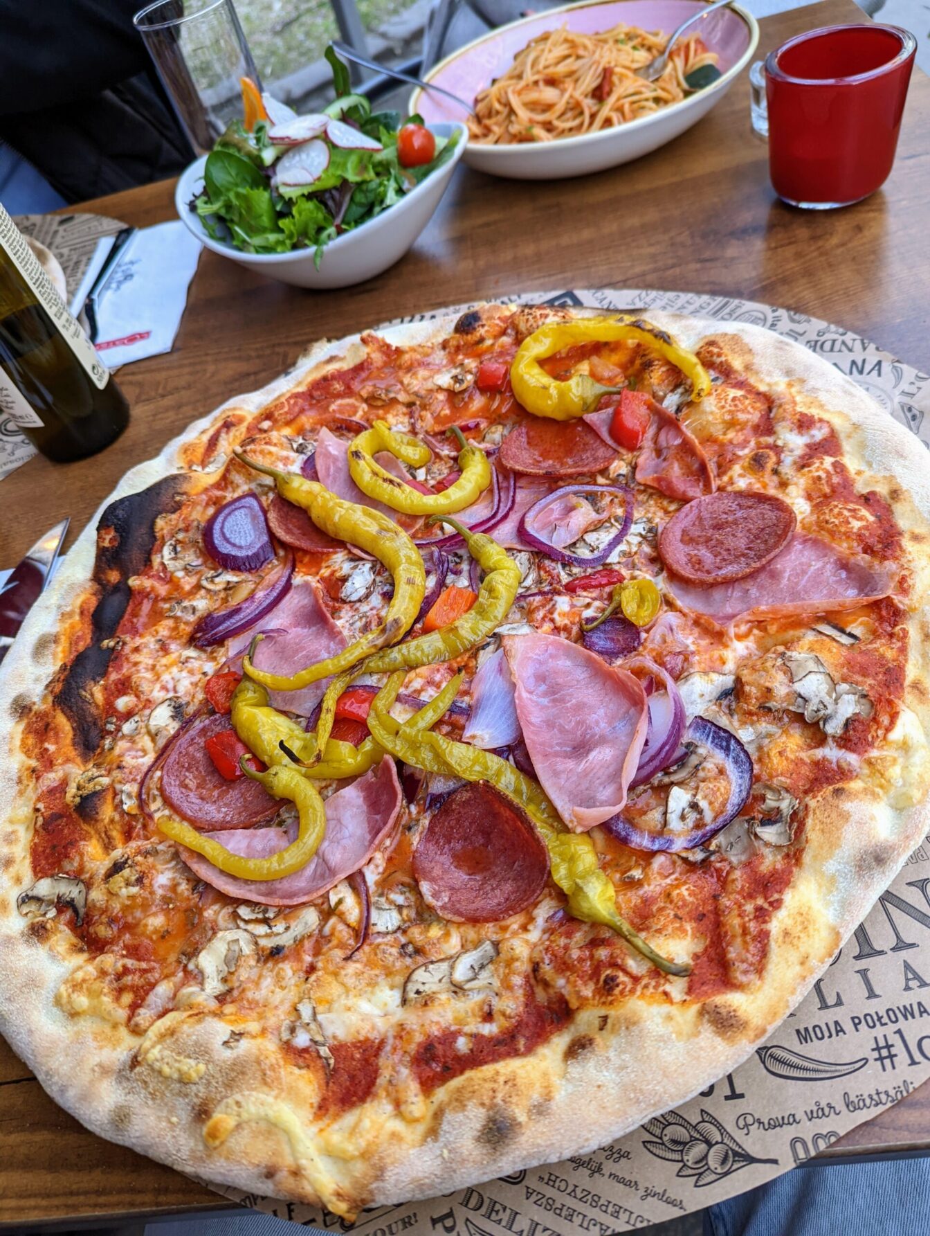 eine Pizza steht auf einem Tisch im Gastgarten der Pizzeria L'Osteria in der Florianigasse in Wien