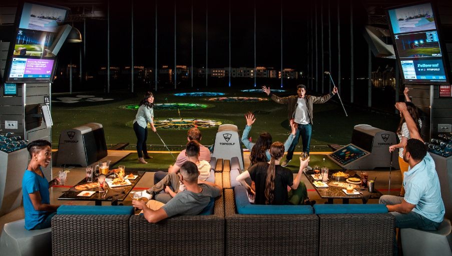 Eine Gruppe Freunde spielt abends bei Topgolf Wien