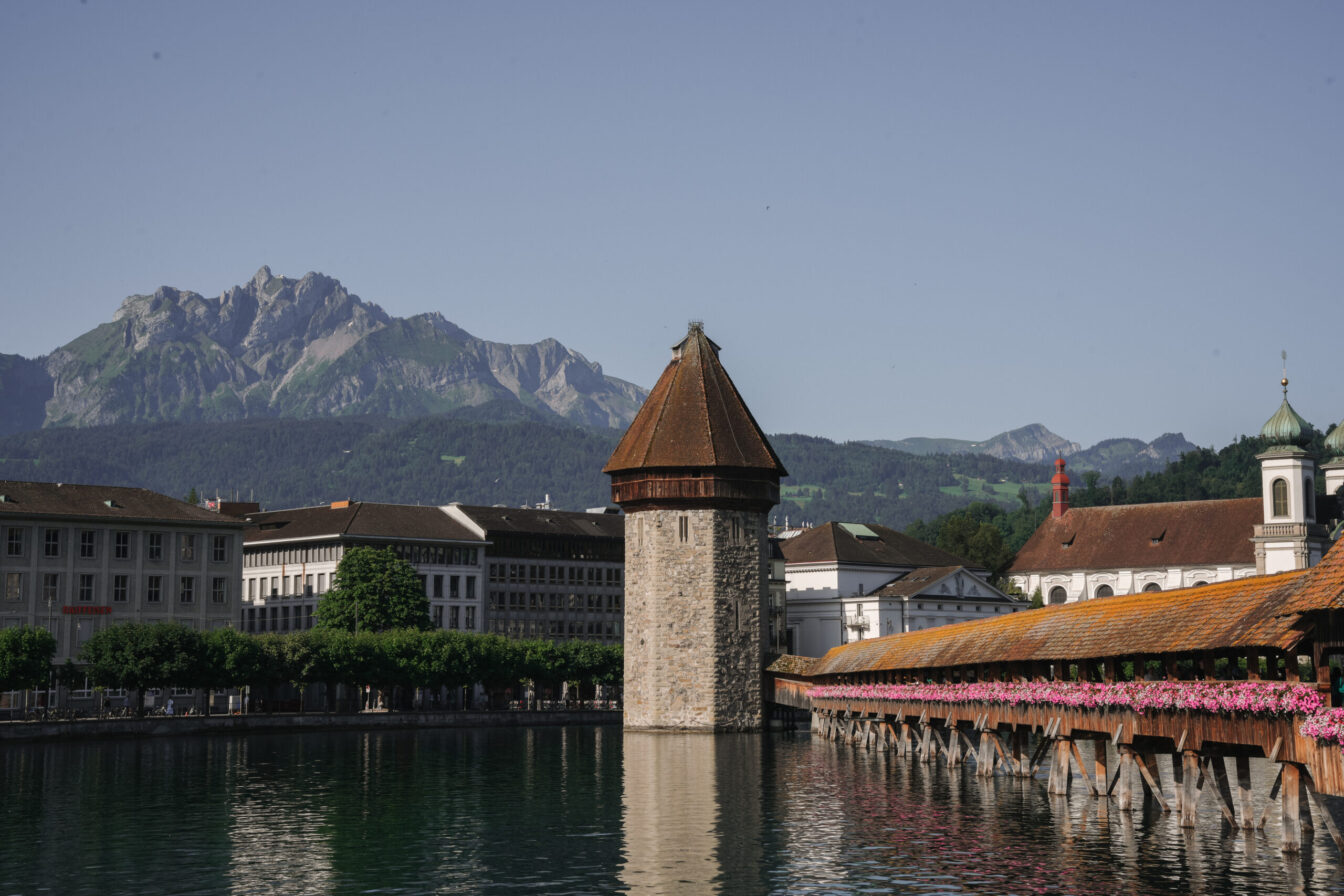 Die Kapellbrücke in Luzern mit dem Fluss Reuss und dem Bergpanorama im Hintergrund.