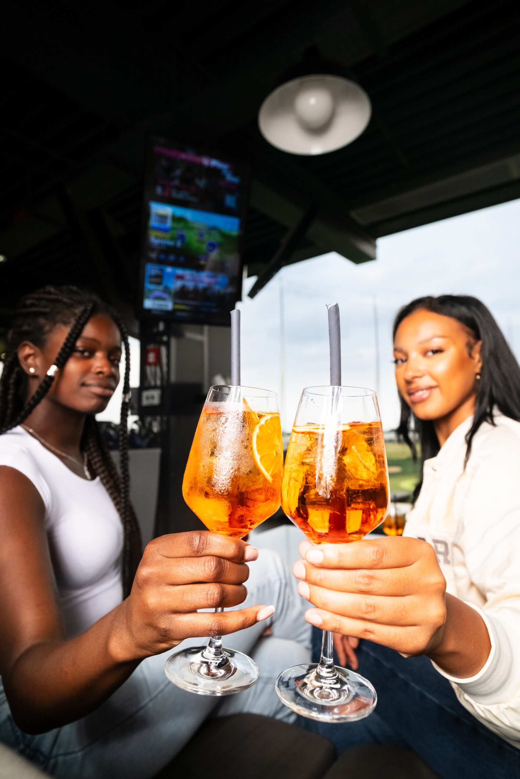 Zwei Frauen stoßen mit Aperol an (c) Topgolf